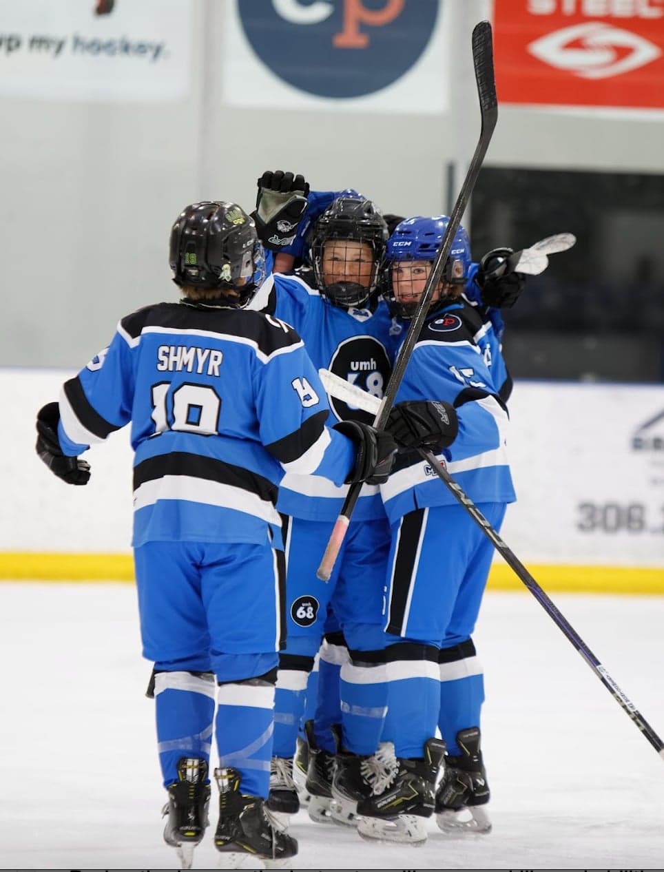 Blue-jersey teammates gather for a celebratory hug.