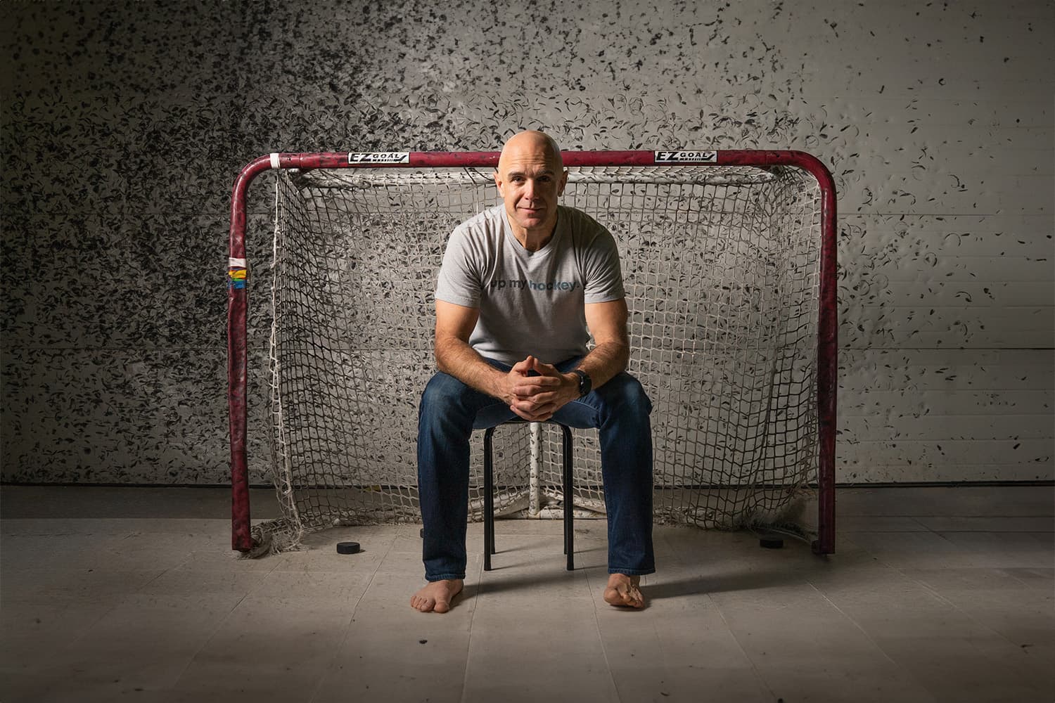 Jason Podollan seated in front of a hockey net